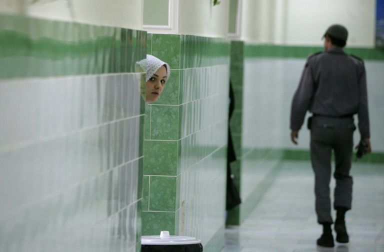 A prisoner peeks out at the hallway at Tehran’s Evin prison in June 2006. — AFP