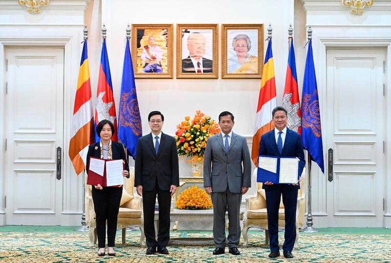 $!Mr Lee (second left) and Mr Hun (second right) witness the exchange of a memorandum of understanding between Invest Hong Kong and the Council for the Development of Cambodia.