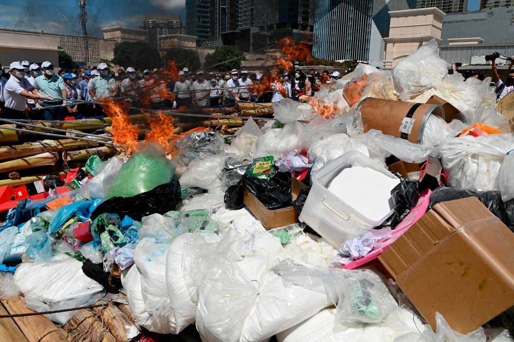 Cambodian Minister of Interior Sar Kheng (3rd L), Ke Kim Yan (2nd L), Cambodia’s deputy prime minister and chief of the National Authority for Combating Drugs, stand next to government officials as they burn illegal seized drugs during a destruction ceremony to mark the United Nations’ “International Day against Drug Abuse and Illicit Trafficking” in Phnom Penh on June 26, 2022. AFPPIX
