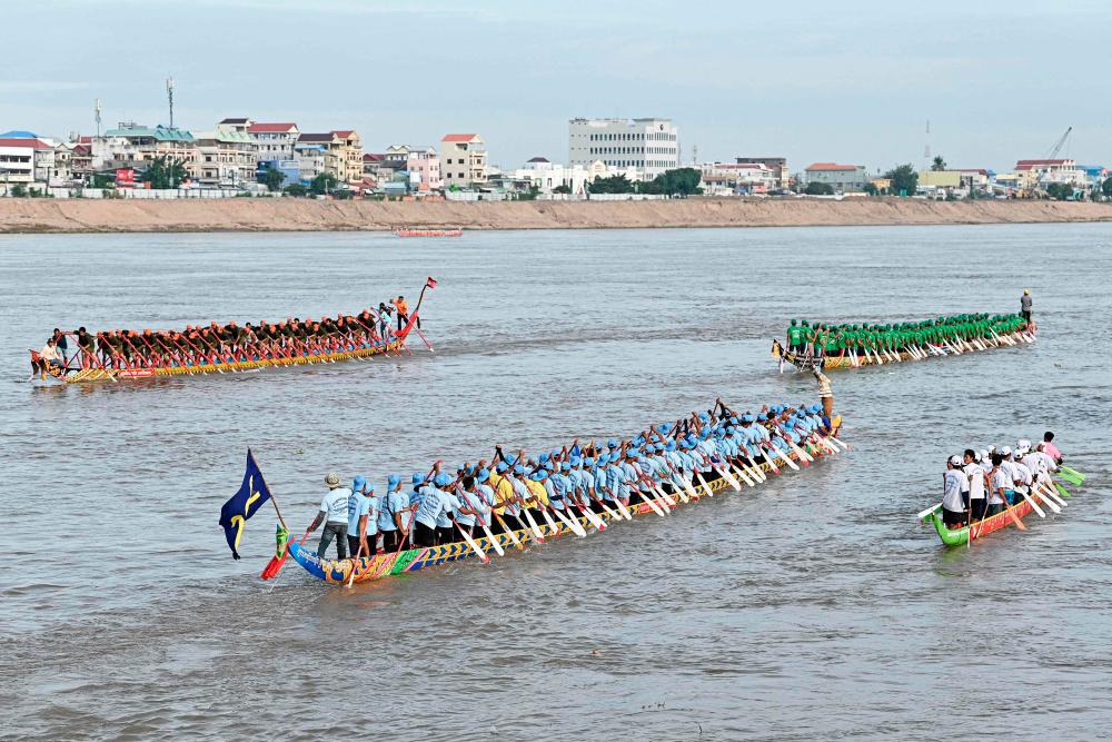 Participants row their dragon boats during a rehearsal for the Cambodian Water Festival on the Tonle Sap river in Phnom Penh. - AFPPIX