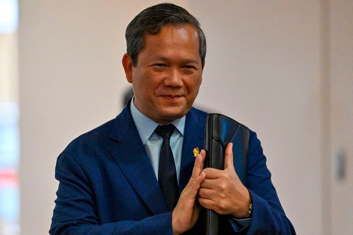 Cambodia’s Prime Minister Hun Manet greets people as he arrives to attend a meeting at the National Assembly building in Phnom Penh on August 25, 2025, where Cambodian lawmakers are expected to pass laws allowing for citizenship to be stripped. (Photo by TANG CHHIN Sothy / AFP)