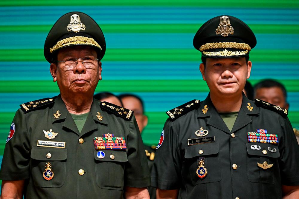 General Hun Manet (R), Commander of the Royal Cambodian Army and eldest son of Prime Minister Hun Sen, and Tea Banh (L), Minister of National Defence, pose for photos during a promotion ceremony at the Ministry of Defence in Phnom Penh//AFP