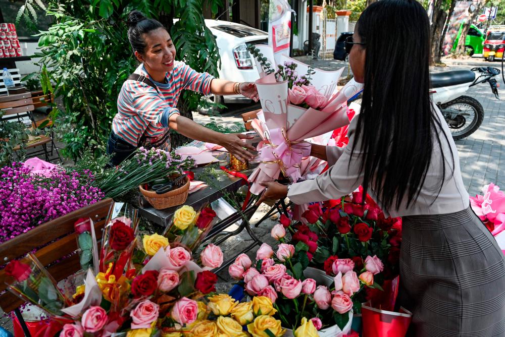 A woman buys flowers on Valentine's Day in Phnom Penh on February 14, 2024. Authorities in Cambodia have issued a stern rebuke to students to avoid inappropriate activities this Valentine's Day, warning them of the perils of losing dignity. - AFPPIX