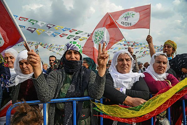 Supporters of Peoples’ Democratic Party (HDP) wave party flags and flash victory sign during an election campain rally of HDP in Batman, south east Turkey — AFP