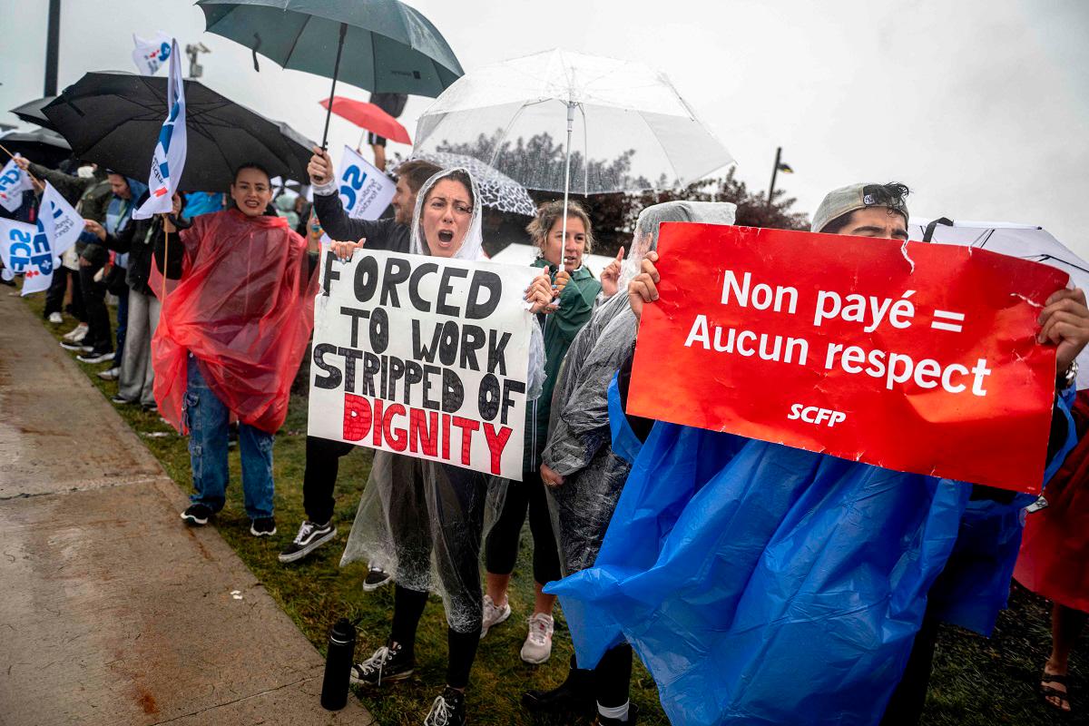 Flight attendants protest in front of Pierre-Elliott Trudeau Airport in Montreal, Quebec, Canada, on August 17, 2025. - ANDREJ IVANOV / AFP