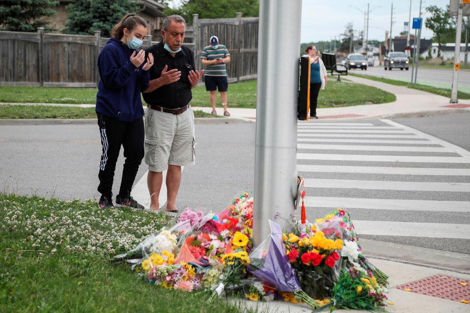 Abdullah Alzureiqi and his daughter Hala say a prayer at the fatal crime scene where a man driving a pickup truck jumped the curb and ran over a Muslim family in what police say was a deliberately targeted anti-Islamic hate crime, in London, Ontario, Canada June 7, 2021. — Reuters