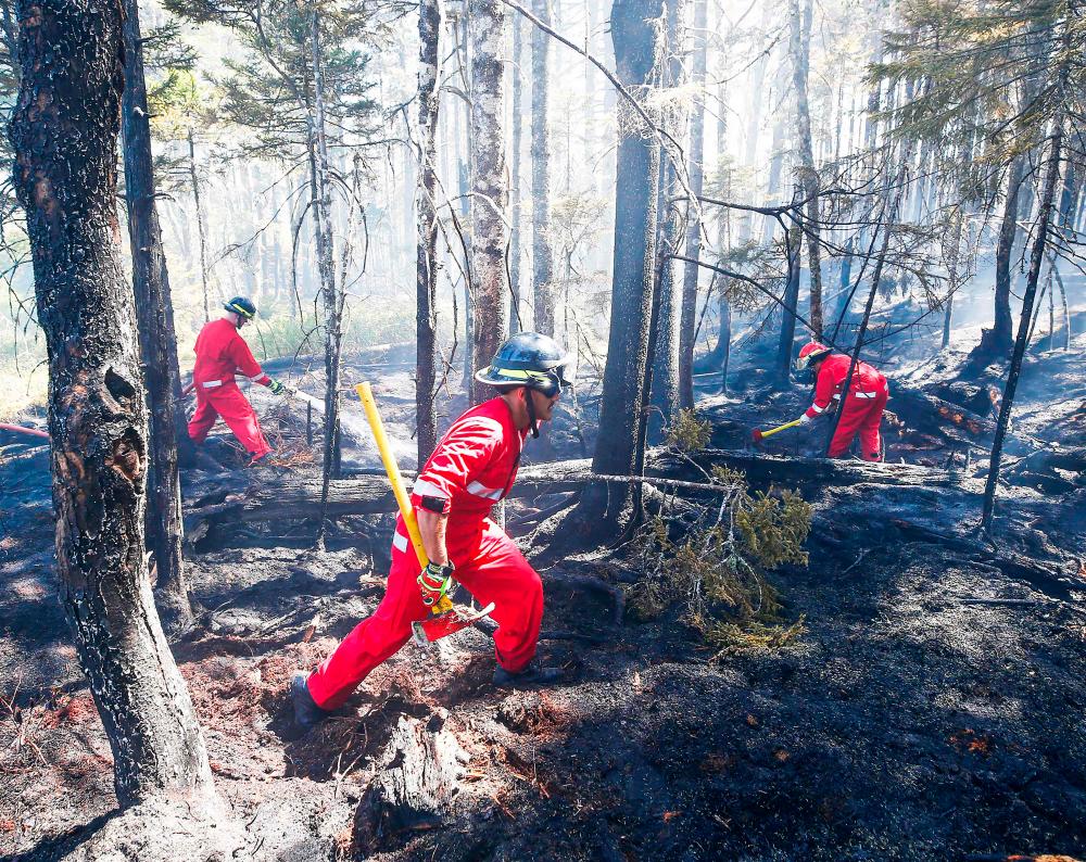 In this May 30, 2023, image courtesy of the Nova Scotia Government in Canada, firefighters with Halifax Regional Fire and Emergency work to put out fires in the Tantallon area of Nova Scotia/AFPPix