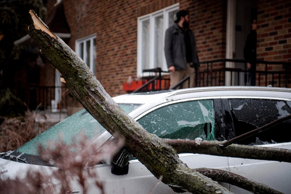 Tree branches fell through a windshield after freezing rain hit parts of Quebec and Ontario in Montreal, Canada, on April 5, 2023. Hydro Quebec estimated that there are some 600,000 power outages throughout the province of Quebec. AFPPIX
