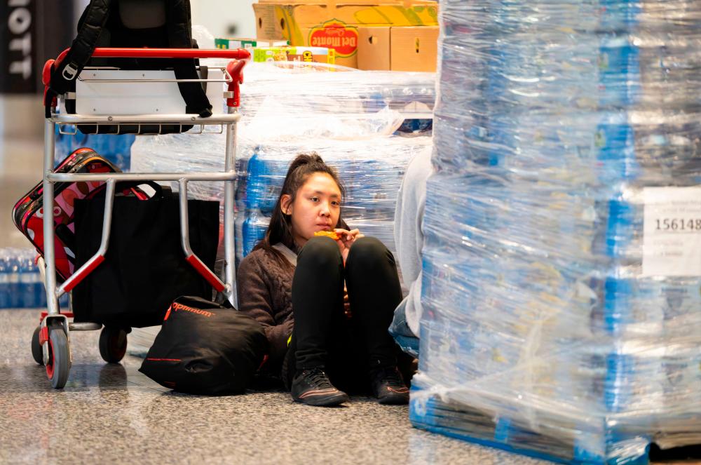 A Yellowknife evacuee sits on the floor in the Calgary Airport, Alberta on August 18, 2023. The order late on August 16, 2023, to evacuate Yellowknife in the Northwest Territories marked the latest chapter of a terrible summer for wildfires in Canada, with tens of thousands of people forced to leave their homes and vast swathes of land scorched/AFPPix
