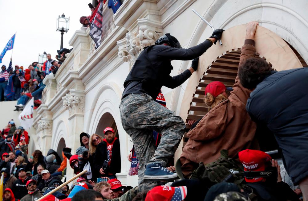 File photo: Pro-Trump protesters scale a wall as they storm the U.S. Capitol Building, during clashes with Capitol police at a rally to contest the certification of the 2020 U.S. presidential election results by the U.S. Congress, in Washington, U.S, January 6, 2021. REUTERSpix