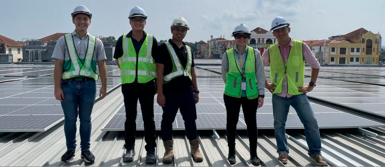 Teh (fourth from left) with her team on the rooftop of Lotus’s Sungai Petani with the solar PV panels.