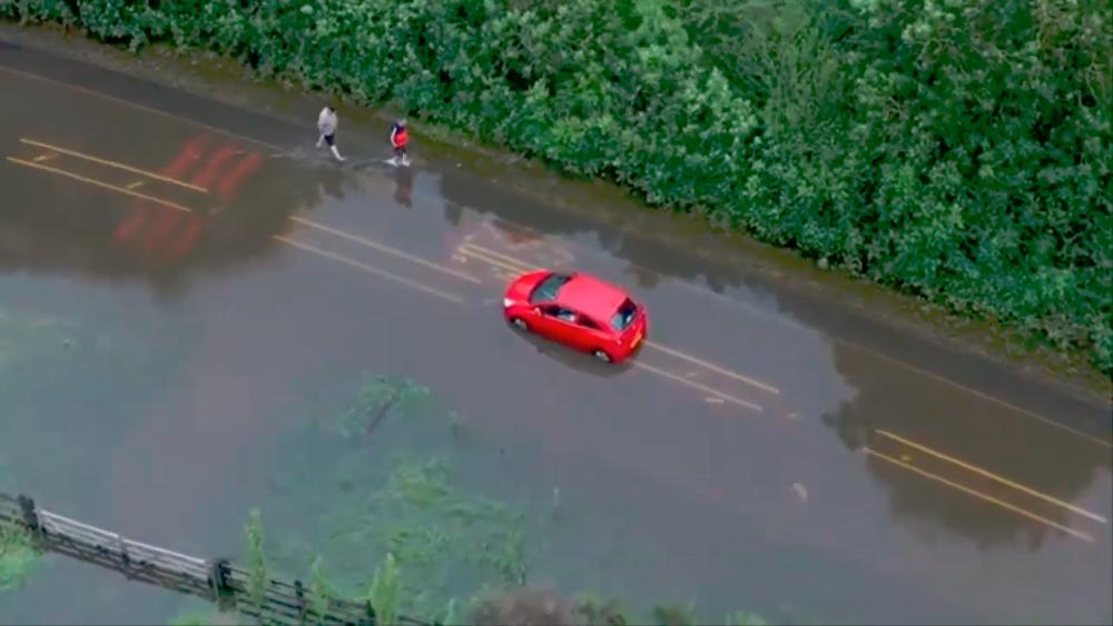 (Video) Driver seeks help after car left stranded in flood in UK