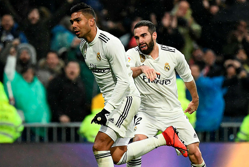 Casameiro celebrates after scoring Real Madrid’s first goal against Sevilla as teammate Dani Carvajal joins in. — AFP
