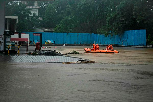 National Disaster Response Force (NDRF) personnel row a boat through a flooded street, during a rescue operation to help trapped civilians following heavy rainfall in Chennai–AFPPix