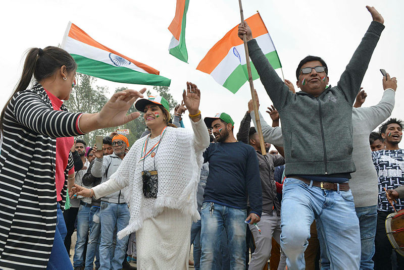 People dance and wave the national flag as they wait for the return of Indian pilot Indian Air Force (IAF) Wing Commander Abhinandan Varthaman at the India-Pakistan Wagah border on March 1, 2019. — AFP