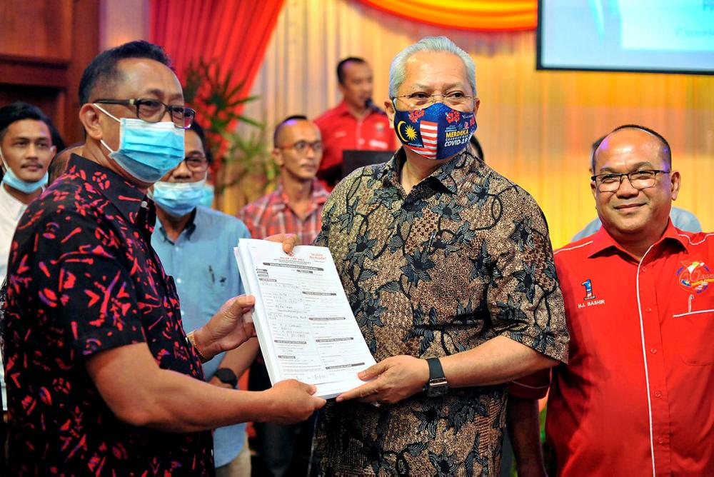 Former Labuan Amanah division chief, Chemat Mustapha (left) led the group in submitting their application forms to Barisan Nasional (BN) secretary-general, Tan Sri Annuar Musa (middle) and Labuan Umno head, Datuk Bashir Alias (right).-Bernama