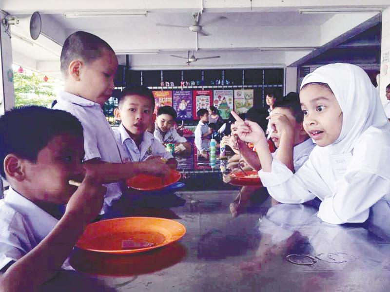 Farizah Rasfan chatting with her classmate during recess at Sekolah Jenis Kebangsaan (C) Karak in Pahang.