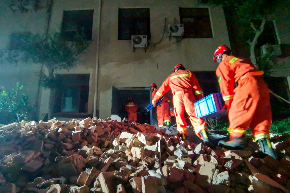 This photo taken on July 12, 2021 shows rescuers searching at the site of a hotel after it collapsed leaving at least one dead and 10 others missing in the city of Suzhou in China's eastern Jiangsu province. – AFP