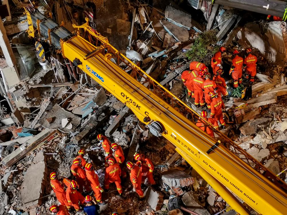 This photo taken on July 12, 2021 shows rescuers searching at the site of a hotel after it collapsed leaving at least one dead and 10 others missing in the city of Suzhou in China's eastern Jiangsu province. – AFP