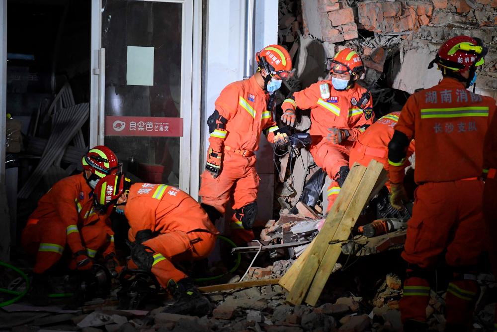 This photo taken on April 29, 2022 shows rescuers searching for survivors at a collapsed six-storey building in Changsha, central China’s Hunan province. Dozens of people were trapped under a building which collapsed in central China, officials said on April 30, as rescuers clawed through the rubble and used buzzsaws to pull several survivors free. AFPPIX