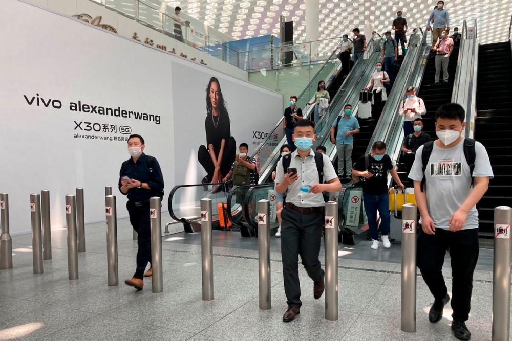 Travellers wearing face masks following the coronavirus disease (Covid-19) outbreak are seen at the Shenzhen Baoan International Airport in Shenzhen, Guangdong province, China May 19, 2020. — Reuters