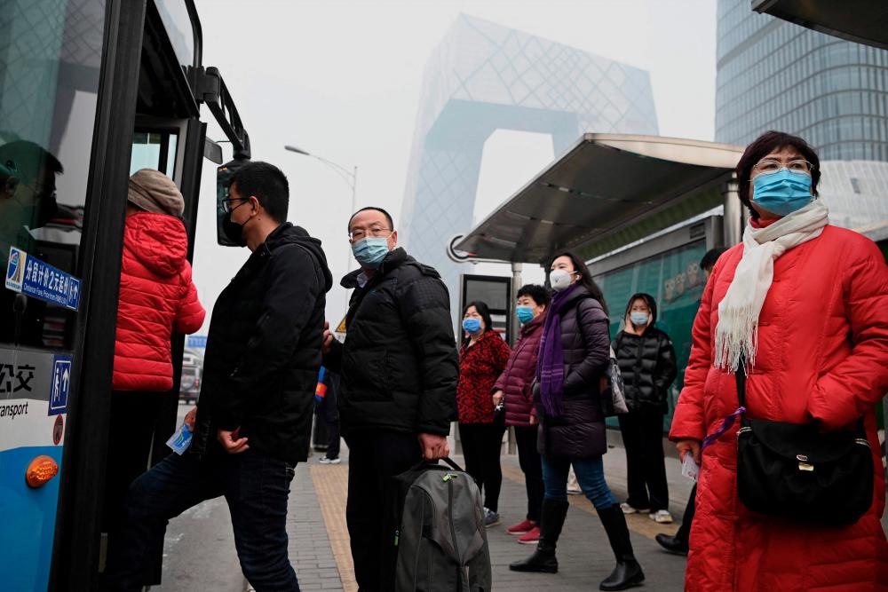 Commuters on a bus at a stop in Beijing on March 5, 2021. China’s leaders set an economic growth target of “above 6 percent” for 2021 on March 5, at the opening of the National People’s Congress in the capital. - AFP