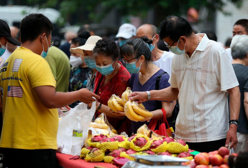 This photo taken on July 9, 2022 shows residents buying bananas at a market in Shenyang in China’s northeastern Liaoning province. AFPPIX
