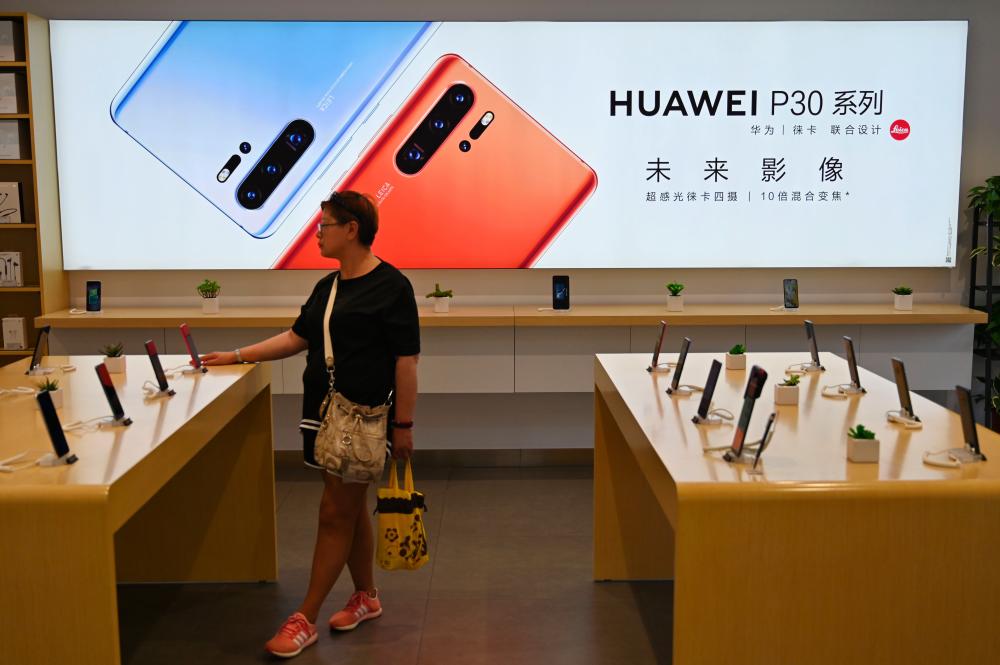 People browse for items in a Huawei store in Shanghai on May 24, 2019. - AFP