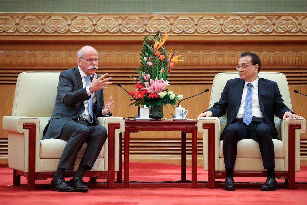 Li (right) listens to Dieter Zetsche, Chairman of the Board of Management of Daimler AG and Head of Mercedes-Benz Cars, during China's development forum at The Great Hall Of The People in Beijing on March 25, 2019. - AFPPIX