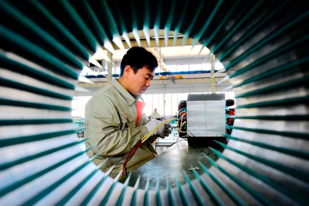 A man at work in an equipment manufacturing company in Weifang, Shandong province, China. Since July 2018, the US has imposed duties on US$250 billion worth of Chinese imports, including US$50 billion in technology and industrial goods at 25%. - REUTERSPIX