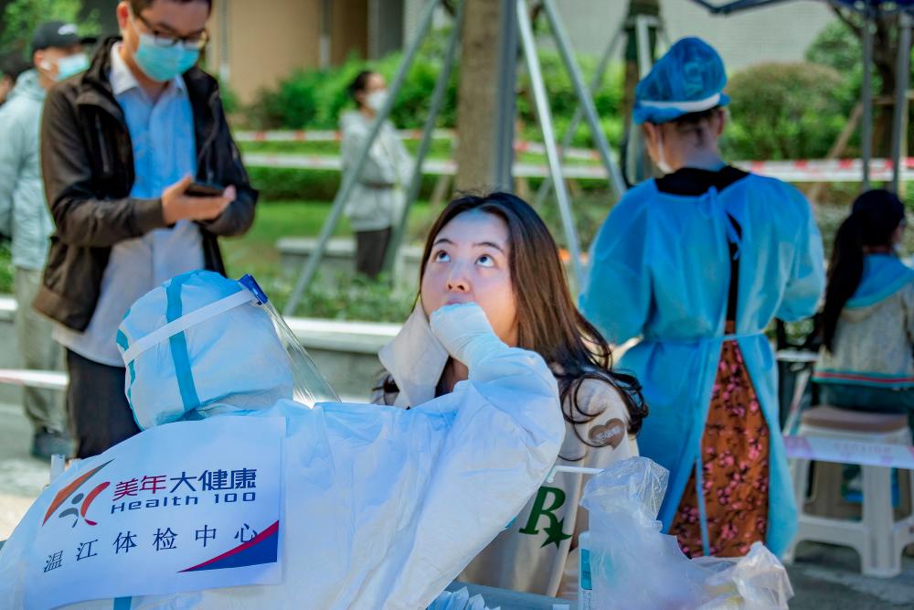 This photo taken on September 17, 2022 shows a health worker taking a swab sample from a resident to be tested for the Covid-19 coronavirus in Chengdu in China's southwestern Sichuan province. - AFPPIX