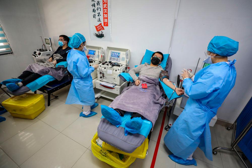 Filepix taken on Feb 18 shows doctors who have recovered from the Covid-19 infection donating plasma in Wuhan in China's central Hubei province. — AFP