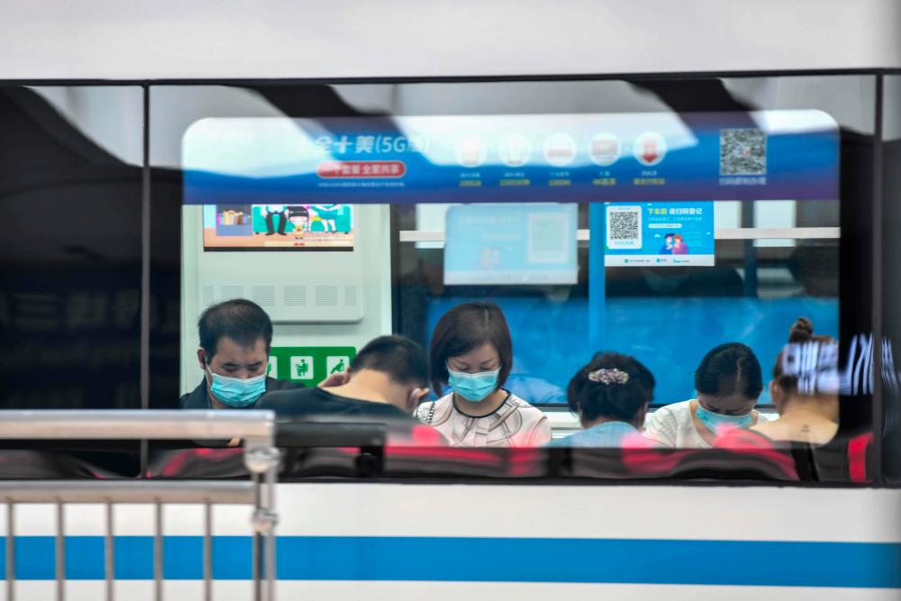 Face mask-clad passengers ride the subway in Wuhan, in China’s central Hubei province on Sept 28, 2020. — AFP