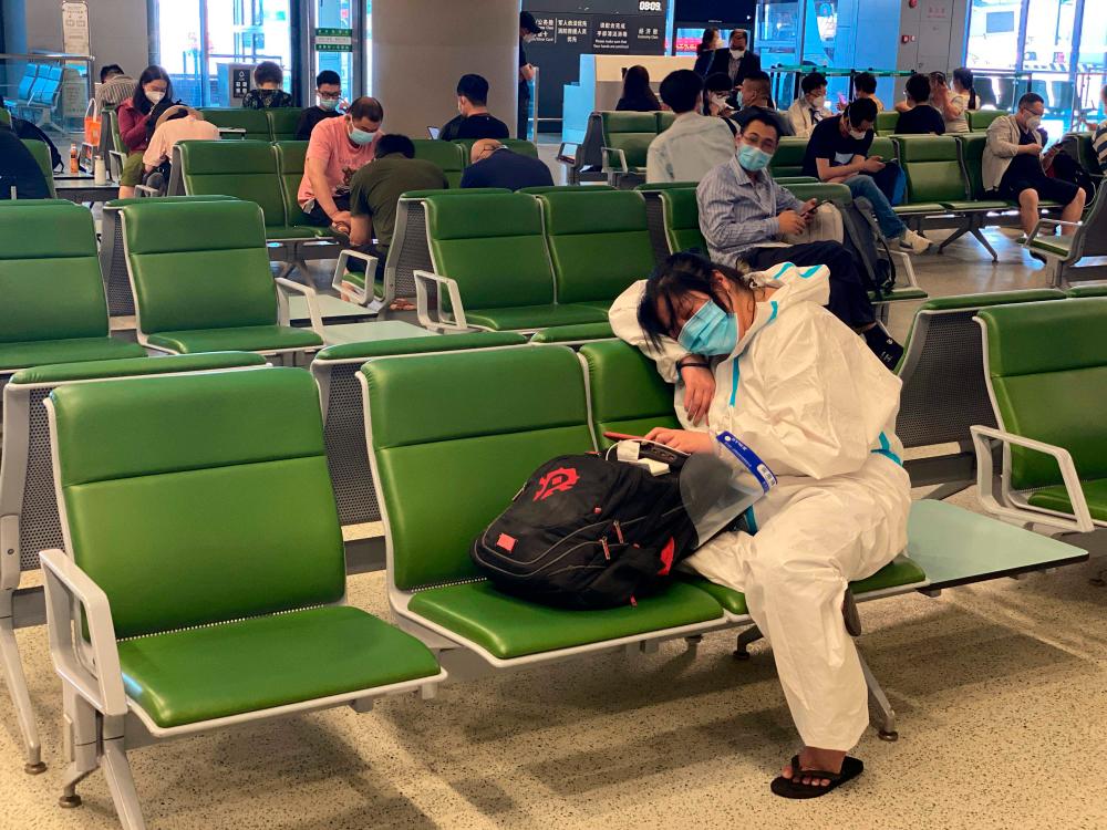 This photo taken on June 18, 2022 shows a person sleeping at the boarding gate of the Shanghai Hongqiao International Airport in Shanghai. AFPPIX