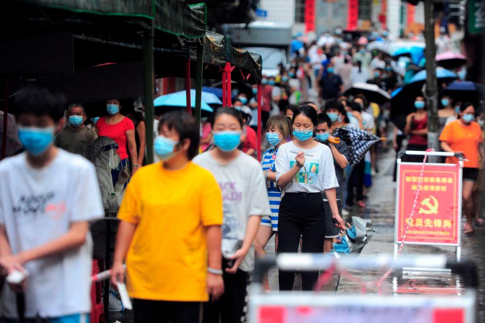 Residents and tourists queue to undergo nucleic acid tests for the Covid-19 coronavirus in Sanya in China’s southern Hainan province on August 8, 2022. AFPPIX