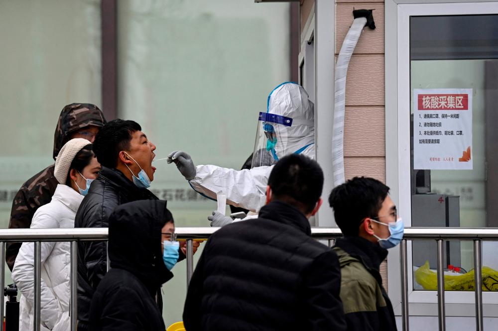 A man receives a nucleic acid test to check for the Covid-19 coronavirus at a testing centre along a street in Beijing on January 21, 2022. AFPPIX