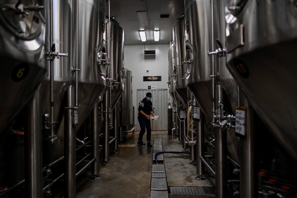 $!This photo taken on November 21, 2020 shows an employee working at No. 18 Brewery in Wuhan, China’s central Hubei province. AFP / Hector RETAMAL