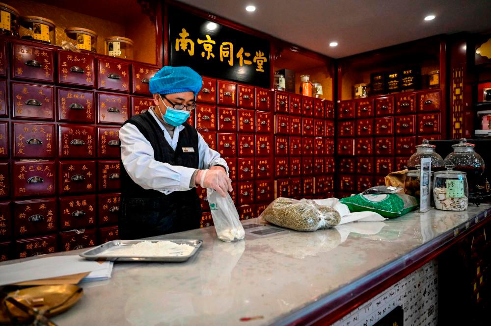 Filepix: The photo taken on December 23, 2022 shows a medical employee working at a traditional Chinese medicine pharmacy in Beijing. AFPPIX