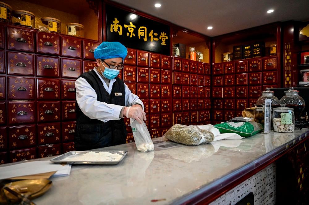 The photo taken on December 23, 2022 shows a medical employee working at a traditional Chinese medicine pharmacy in Beijing. AFPPIX