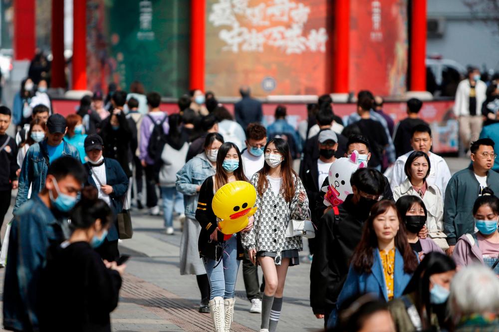 This photo taken on May 4, 2021 shows people visiting a business street in Shenyang, in China's Liaoning province. –AFP