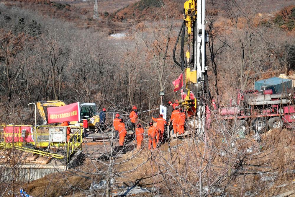 Members of a rescue team work at the site of a gold mine explosion where 22 miners are trapped underground in Qixia, in eastern China’s Shandong province on January 18, 2021. At least 12 gold miners trapped hundreds of metres underground in China for more than a week have sent up a note warning that they are injured, surrounded by water and urgently need medicine. - China OUT / AFP / -