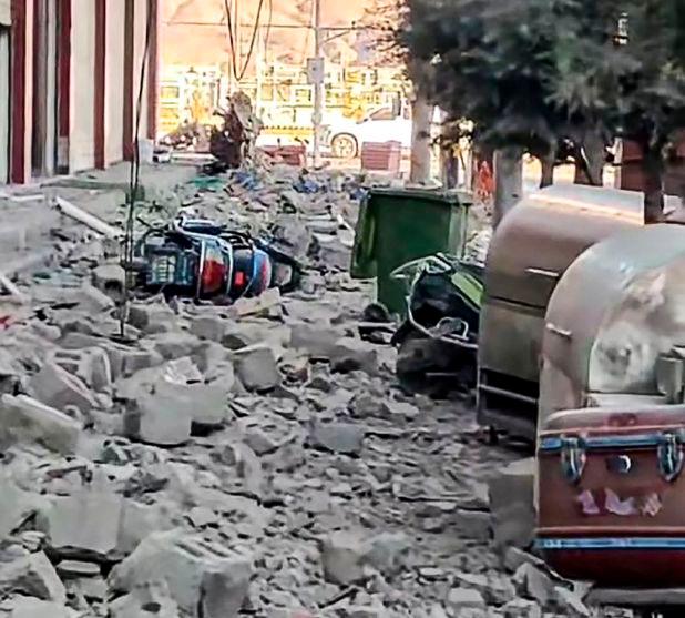 This frame grab from a user-generated content (UGC) video of a Douyin user on January 7, 2025 shows a fallen motorcycle amid debris on a road in Lhatse County in Shigatse city in China's Tibet after an earthquake struck the area. - AFPPIX