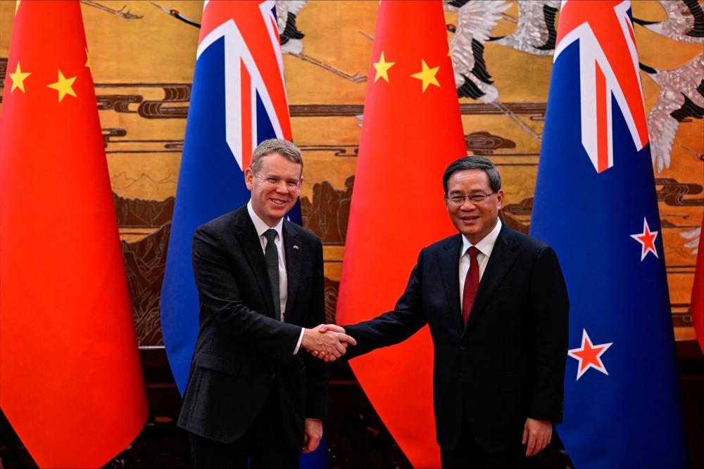 Chinese Premier Li Qiang (R) shakes hands with New Zealand Prime Minister Chris Hipkins during a signing ceremony at the Great Hall of the People in Beijing on June 28, 2023. AFPPIX