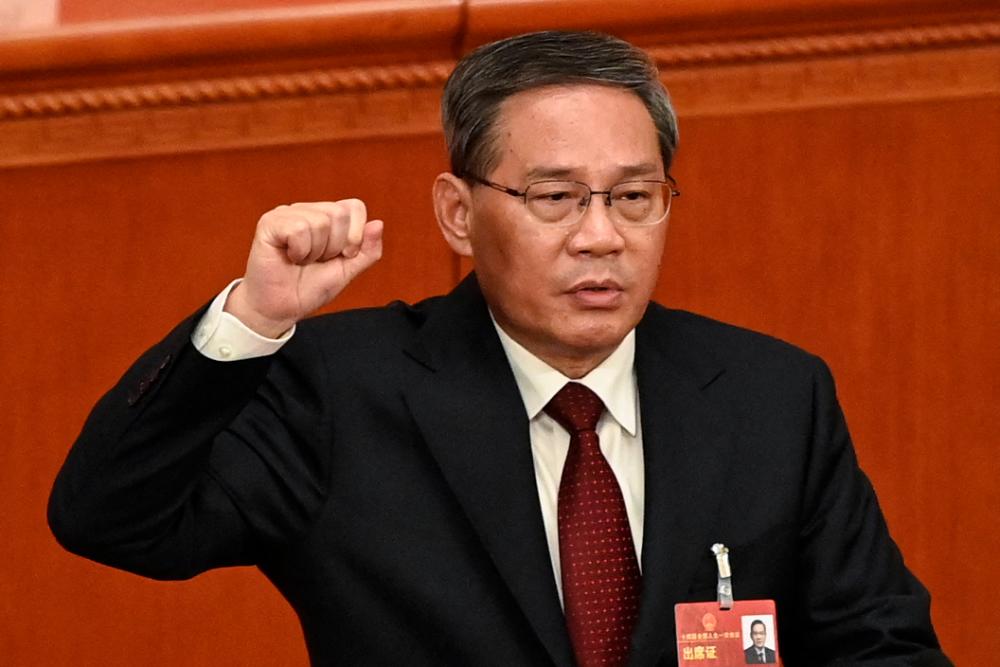 China’s newly-elected Premier Li Qiang takes an oath after being elected during the fourth plenary session of the National People’s Congress (NPC) at the Great Hall of the People in Beijing on March 11, 2023/AFPPix