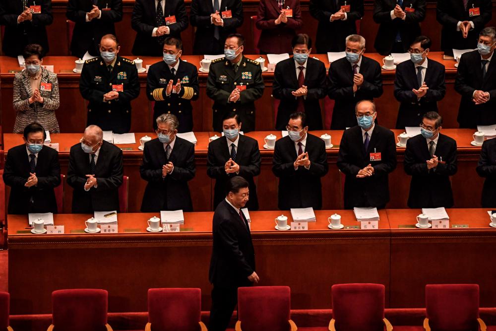 Delegates applaud as China’s President Xi Jinping (bottom C) arrives for the opening session of the National People’s Congress (NPC) at the Great Hall of the People in Beijing on March 5, 2021. - AFP
