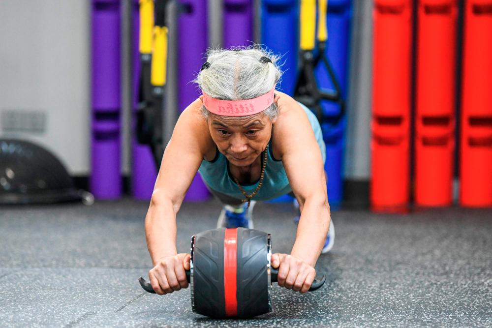This photo taken on September 17, 2020 shows Chen Jifang, 70, working out at a gym in Shanghai. The grandmother from Shanghai has become a minor celebrity in recent months in China as her newfound and unlikely love for working out made national headlines. -/ AFP / STR