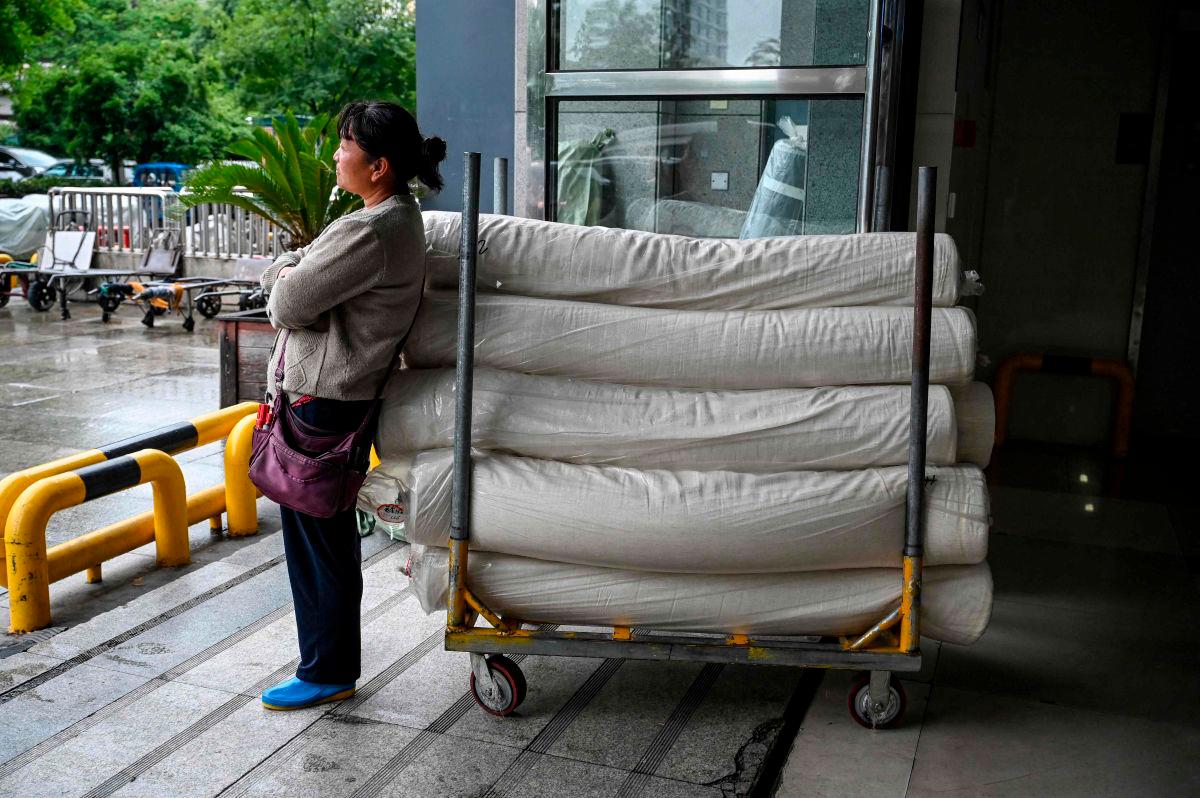 A woman waits with rolls of fabric at an entrance of the Keqiao China Textile City, one of the biggest textile markets in Asia, in Shaoxing in China’s eastern Zhejiang province on May 8, 2025. AFPpix