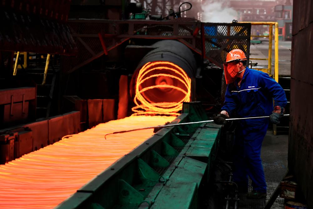 A Chinese employee sorts hot red steel at a steel plant in Zouping in China's eastern Shandong province. AFPPIX