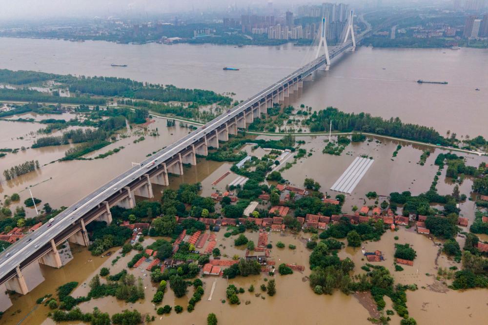 This aerial view shows the inundated Tianxingzhou island, which is set to be a flood flowing zone to relieve pressure from the high level of water in Yangtze River, in Wuhan in China's central Hubei province on July 13, 2020. — AFP