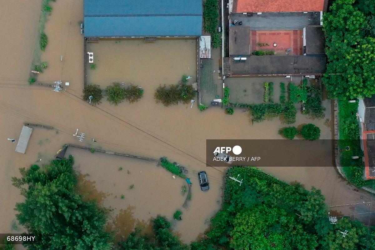An aerial view shows stranded cars (C) in flooding due to heavy rains at Xinanzhuang village in Miyun district, on the outskirts of Beijing on July 29, 2025. Heavy rain in Beijing killed 30 people and forced authorities to evacuate tens of thousands as swathes of northern China were lashed by torrential downpours that sparked deadly landslides, state media said July 29. - ADEK BERRY / AFP